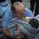 A man tries to warm up a child. Wednesday, Oct. 28, 2015